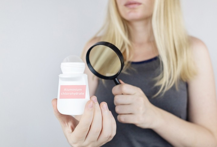 An Image Showing a Woman Using Magnifying Glass to Dectect Product Ingredients